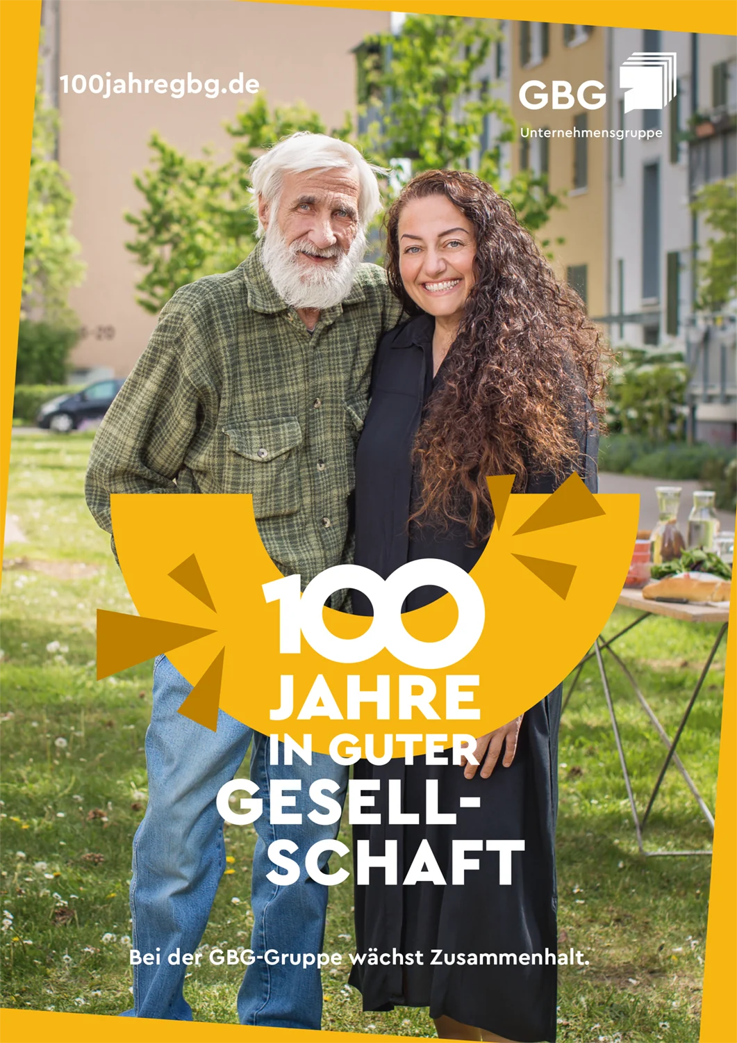 KI-basierte Bildbeschreibung: Ein älterer Mann mit weißem Bart und eine jüngere Frau mit langen Locken stehen lächelnd zusammen im Freien. Der Text lautet: 100 Jahre in guter Gesellschaft. Bei der GBG-Gruppe wächst der Zusammenhalt.